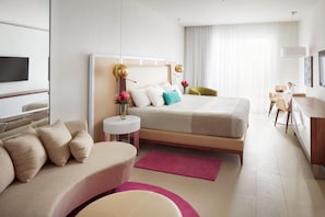 A modern hotel room with a bed, a desk, a chair, and a TV. - Azul Beach Resort Negril By Karisma (Negril)
