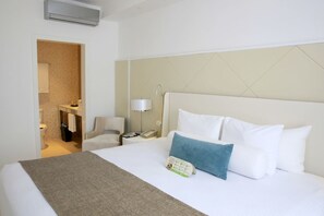 A hotel room with a bed, a bedside table, a lamp, and a bathroom visible through an open door. - Azul Beach Resort Negril By Karisma (Negril)