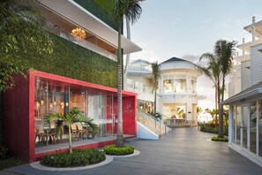 A modern hotel with a red facade, a green wall, and a glass entrance. - Azul Beach Resort Negril By Karisma (Negril)