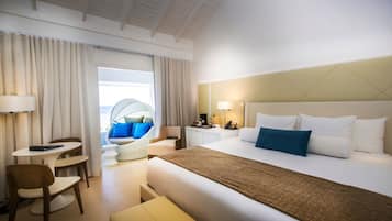 A hotel room with a bed, a desk, a chair, a sofa, and a view of the outside.