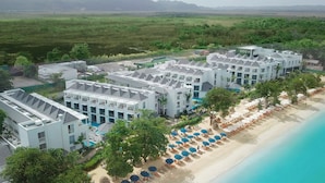 A resort with multiple buildings, a pool, and a beach with umbrellas. - Azul Beach Resort Negril By Karisma (Negril)