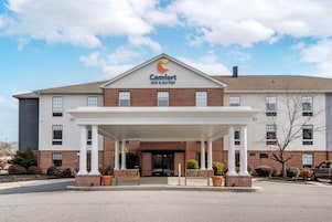 Un Comfort Inn & Suites con entrada cubierta, fachada de ladrillo y cielo despejado.