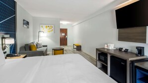A hotel room with a large bed, a desk with a coffee maker, a TV, a sofa, and a small table. - Comfort Inn & Suites Lexington South (Lexington)