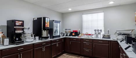 A modern kitchen with a coffee station, microwave, toaster, and a large window.