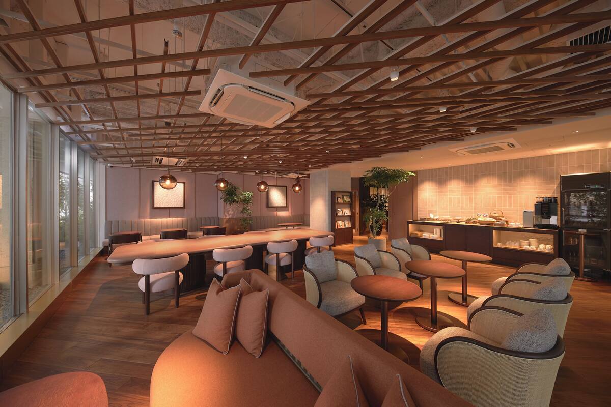 Un intérieur moderne avec un plafond en bois, un espace bar, des sièges et une cuisine.