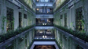 A multi-level atrium with a central seating area featuring sofas and tables, surrounded by lush vertical gardens. - Good Nature Hotel Kyoto (Kyoto)