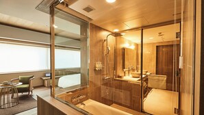 Une salle de bain moderne avec une douche à parois de verre, un grand miroir et une baignoire.