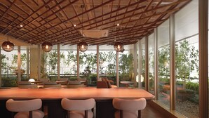 A modern interior with a large wooden ceiling, large windows, and a central bar area with seating. - Good Nature Hotel Kyoto (Kyoto)