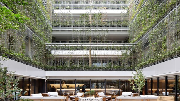 A spacious atrium with a central fire pit surrounded by seating areas, a high ceiling with greenery, and a modern architectural design. - Good Nature Hotel Kyoto (Kyoto)