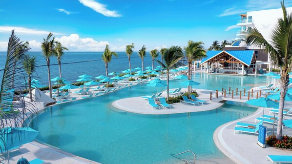 A resort pool with clear blue water, surrounded by palm trees and lounge chairs. - Margaritaville Island Reserve Riviera Maya (Puerto Morelos)