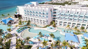 A resort with multiple swimming pools, sun loungers, and a large building with balconies. - Margaritaville Island Reserve Riviera Maya (Puerto Morelos)