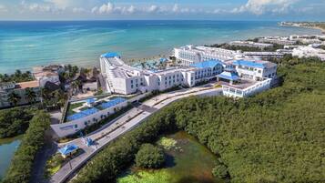 Een resort met meerdere gebouwen, een zwembad en uitzicht op de oceaan.