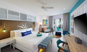 A hotel room with a bed, a desk, a chair, a TV, and a balcony with a view of the outside. - Margaritaville Island Reserve Riviera Maya (Puerto Morelos)