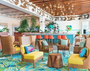 A spacious lobby with high ceilings, a central bar area, and comfortable seating arrangements. - Margaritaville Island Reserve Riviera Maya (Puerto Morelos)
