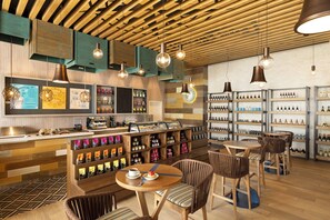 A modern coffee shop interior with wooden accents, a bar area, and shelves of beverages. - Margaritaville Island Reserve Riviera Maya (Puerto Morelos)