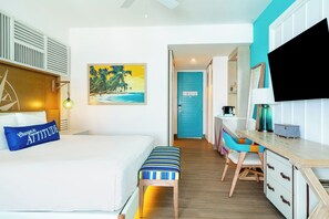 A hotel room with a bed, a desk, a chair, a TV, and a painting of a beach scene. - Margaritaville Island Reserve Riviera Maya (Puerto Morelos)