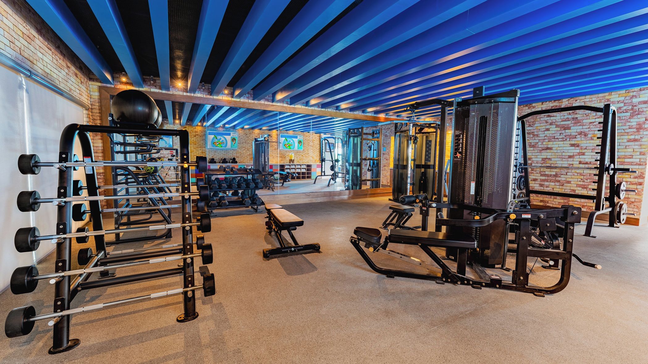 A gym with various exercise equipment, including weight machines and dumbbells.