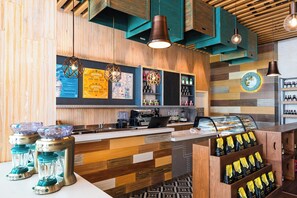 A bar area with wooden paneling, a coffee machine, and a display of bottled beverages. - Margaritaville Island Reserve Riviera Maya (Puerto Morelos)