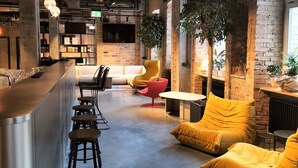 Decoração moderna com área de bar, assentos e uma planta grande.