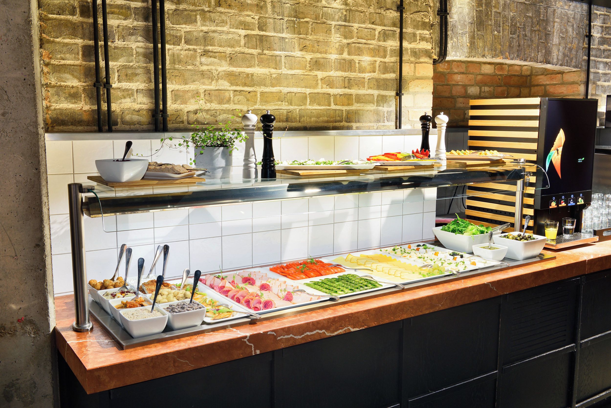 A buffet with various food items and a coffee machine.
