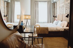 A hotel room with a bed, a desk, a chair, a lamp, and a large mirror. - Dwor Uphagena Arche Gdańsk (Gdańsk)