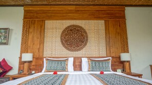 A hotel room with a large bed, two nightstands, a wooden headboard, and a decorative wall hanging. - Sakti Garden Resort & Spa (Ubud)