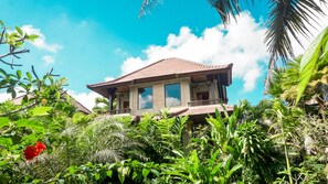A traditional two-story building with a tiled roof, surrounded by lush tropical vegetation. - Sakti Garden Resort & Spa (Ubud)