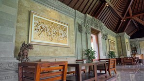 A spacious lobby with high ceilings, ornate columns, and a large abstract painting on the wall. - Sakti Garden Resort & Spa (Ubud)
