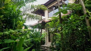 A lush garden with a stone pathway leading to a wooden balcony. - Sakti Garden Resort & Spa (Ubud)