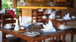 A dining table set with white plates, silverware, and a white napkin. - Sakti Garden Resort & Spa (Ubud)