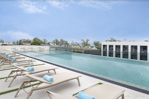 A rooftop pool area with lounge chairs and a clear view of the ocean. - Jonox Phuket Karon (Karon)