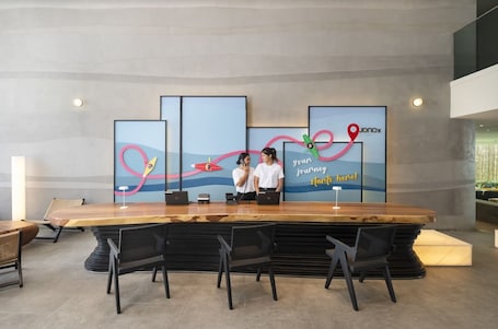 A reception area with a large wooden reception desk, black chairs, and a wall with a colorful abstract design and the text "your journey starts here".