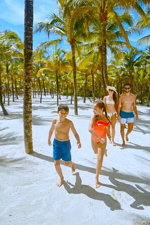 A sandy beach with palm trees and people walking. - Family Selection At Grand Palladium Kantenah (Kantenah)