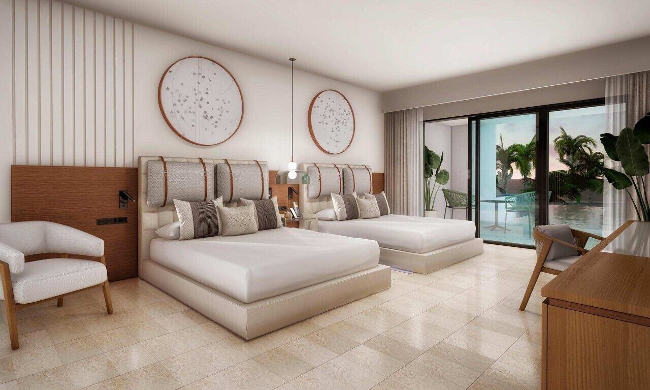 A modern bedroom with a large bed, a seating area, and a view of the outdoors.