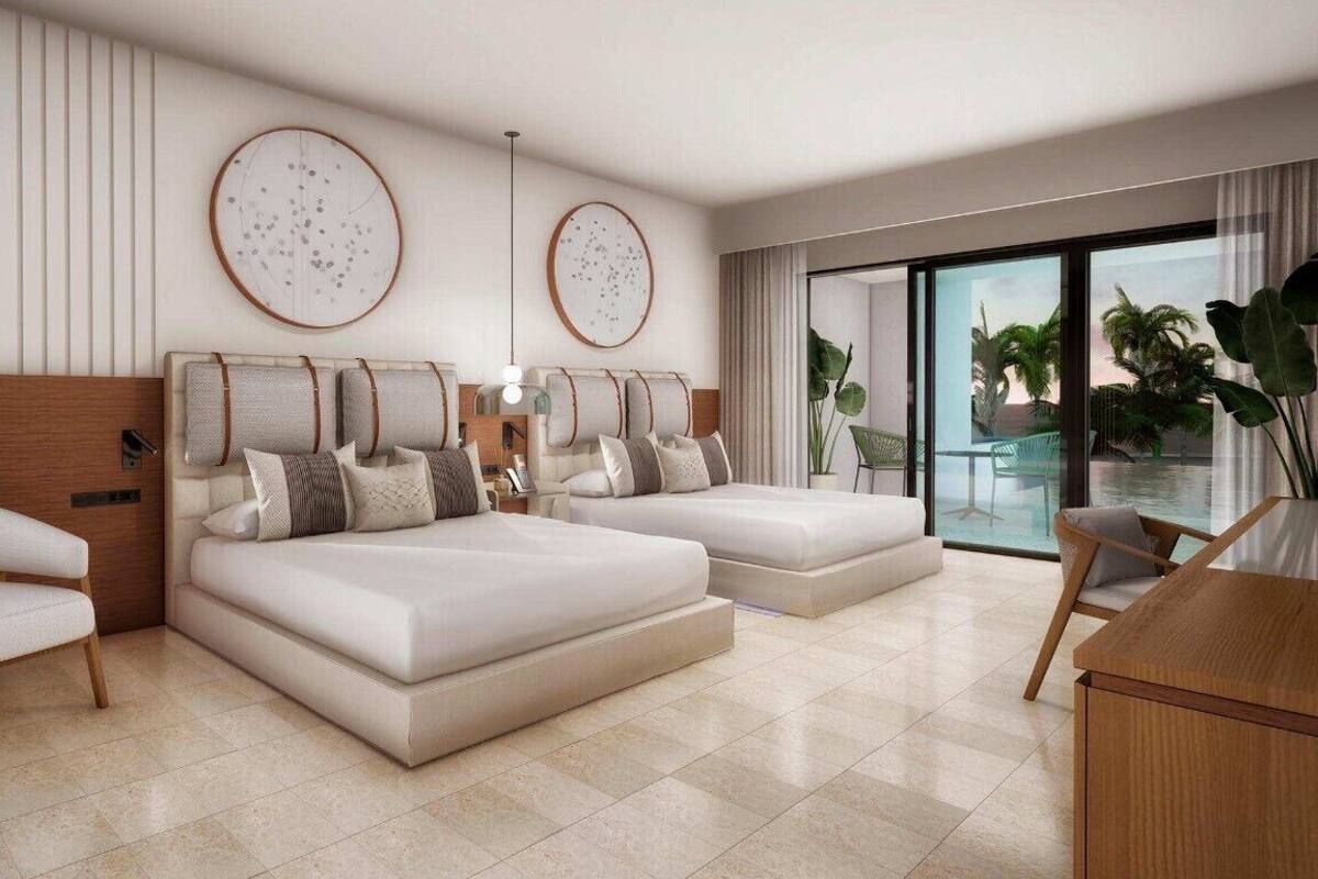 Un dormitorio moderno con una cama grande, un área de descanso y vistas al exterior.