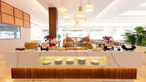 A buffet setup with various food items and a modern interior design. - Family Selection At Grand Palladium Kantenah (Kantenah)