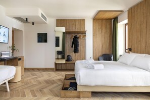 A modern hotel room with a large bed, a desk with a laptop, a chair, a wardrobe, and a mirror. - B&B Hotel Passo Tre Croci Cortina (Cortina d'Ampezzo)