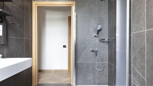 Un baño moderno con ducha, inodoro y lavamanos.