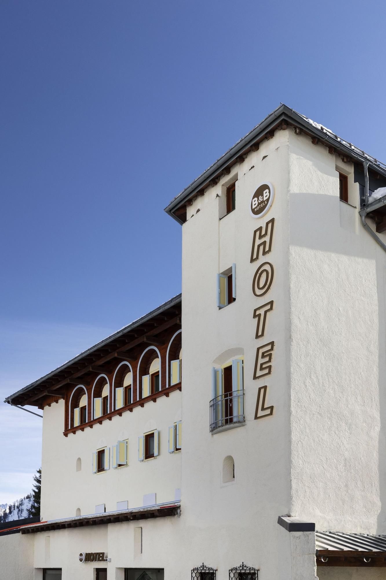 A white building with a sign reading "HOTEL" on the side.