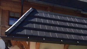 A building with a sloped roof, a mailbox, and a trash bin. - Apartment 'Feldberg' with Shared Garden, Balcony and Wi-Fi (Hinterzarten)