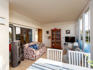 A living room with a sofa, a cabinet, a television, and a fireplace. - Apartment 'Direkt Am See' with Lake View, Private Terrace and Wi-Fi (Malchow)