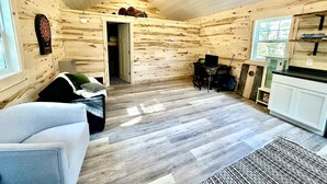 Un interior de cabaña acogedor con detalles de madera, un comedor y una cocina.