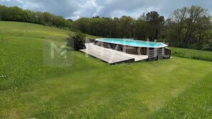 A modern outdoor pool area with a wooden deck and a built-in pool. - EDEN gîte for 2 people with terrace and swimming pool in the heart of the Périgord Noir region (Doissat)