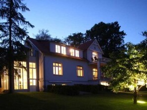 A two-story house with a red roof, multiple windows, and a well-maintained lawn. - Apartment 'Blanck 2' with Lake View, Private Terrace and Wi-Fi (Malchow)