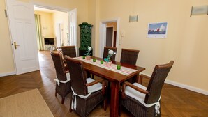 A dining area with a wooden table, wicker chairs, and a green cabinet.