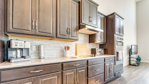 A modern kitchen with dark wood cabinets, a white tiled backsplash, and stainless steel appliances. - Pool Access: Family Gem w/ Views in St Cloud! (St. Cloud)