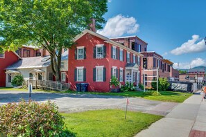A row of red brick townhouses with a front porch and a small tree in the foreground. - Waterbury Studio 12 Mi to Bolton Valley Ski Resort (Waterbury)