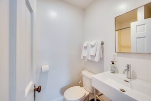 A bathroom with a toilet, sink, and a mirror. - Waterbury Studio 12 Mi to Bolton Valley Ski Resort (Waterbury)