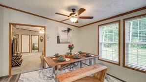 A dining area with a wooden table, benches, and a ceiling fan. There are windows with blinds, a rug, and a door leading to another room. - 1 Mi to Geneva SP: Family Home w/ Game Room & Yard (Geneva)