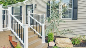 A house with a wooden deck, a staircase with white railings, and a small garden with a rock and a pumpkin. - 1 Mi to Geneva SP: Family Home w/ Game Room & Yard (Geneva)